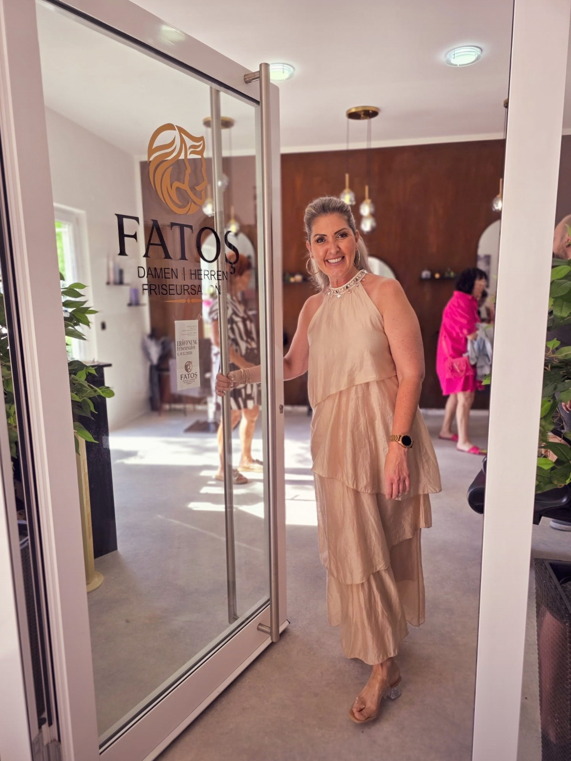 Fatoş im festlichen Kleid empfängt die Gäste an der Glastür des Salons